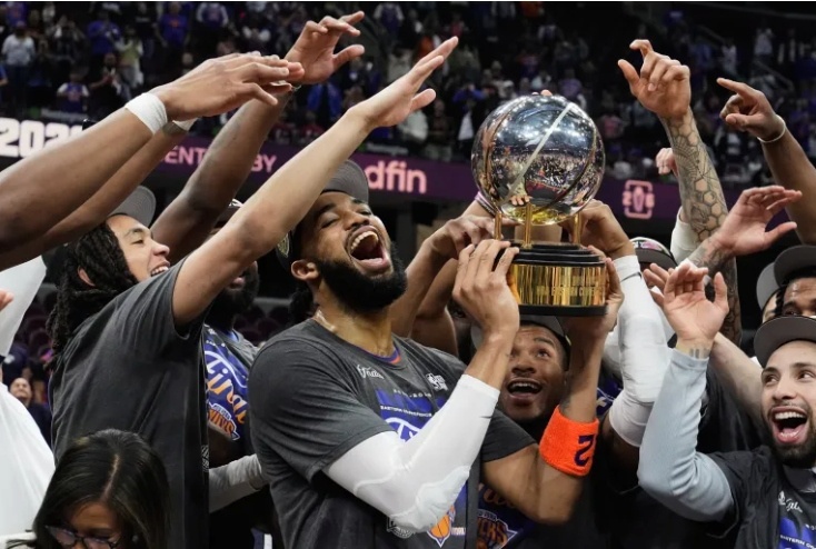 The New York Knicks lifting the Eastern Conference trophy in their Finals jerseys